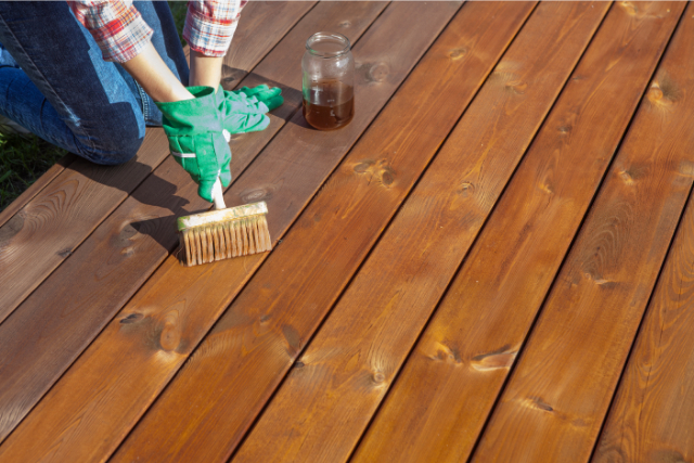 Worker staining a deck