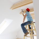 House painter on a ladder painting the ceiling