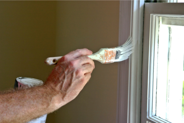 Worker painting window sill